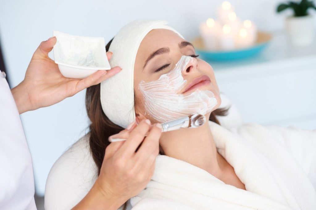 Application au pinceau d'un masque hydratant en institut dans le cadre d'une routine soin peau avant le mariage